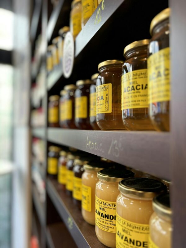 A shelf with jars of honey on it